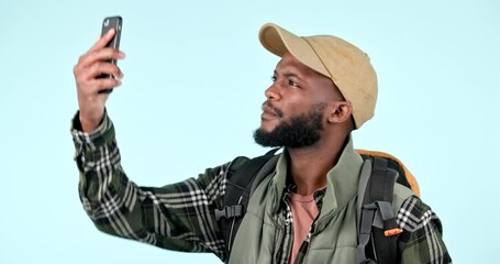 Poster - Lost, phone and man with a backpack in a studio checking signal for online map. Technology, trekking and African male hiker doing research for a camp directions on cellphone by blue background.