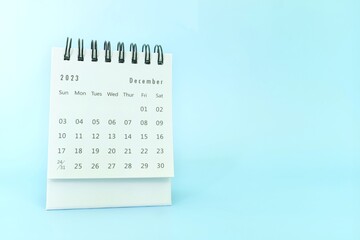 Wall Mural - Selective focus of December 2023 desk calendar on blue background with copy space.