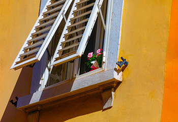 Sticker - Colorful window with shutters and flowers with yellow wall