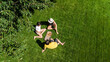 © Iuliia Sokolovska - Family and friends eating pizza on summer picnic in park, relaxing on grass and having fun, aerial drone view from above