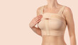 © Tania - Woman wearing a compressing bra with a stipe after breast augmentation surgery.