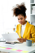 © Daenin - female employee african american.Doing paperwork using the laptop computer in her work station. Businessman, freelance worker, online marketing report, e-commerce telemarketing concept.