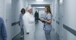 © Framestock - Female doctor, nurse with digital tablet and patient talk. Medic stands in modern clinic corridor with elderly woman after procedures. Medical staff and patients in hospital or medical center hallway.