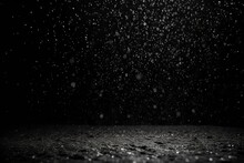 Rain falling on the ground in black and white