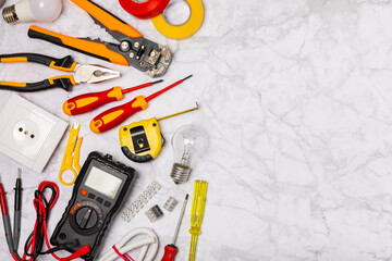 Wall Mural - Electrician tools on light background.Multimeter,construction tape,electrical tape, screwdrivers,pliers,an automatic insulation stripper, socket and LED lamp.Flatley.electrician concept.