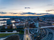Aerial view of modern urban borough at Central train station against colourful sunset sky. Calm water surface reflecting sky. Oslo, Norway