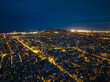 Night cityscape of metropolis. Aerial panoramic view of illuminated streets and buildings in large city. Barcelona, Spain