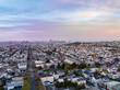 Aerial panoramic view of metropolis. Family houses and residencies in urban neighbourhood, downtown skyscrapers in distance. San Francisco, California, USA