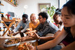 © Marko Geber - Young and diverse group of friends having a pizza party at home