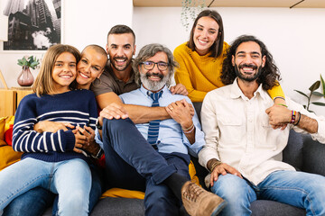 Portrait of big multi generational happy family. Photo group of grandfather, mother, father, aunt, ancle and granddaughter sitting together on sofa at home