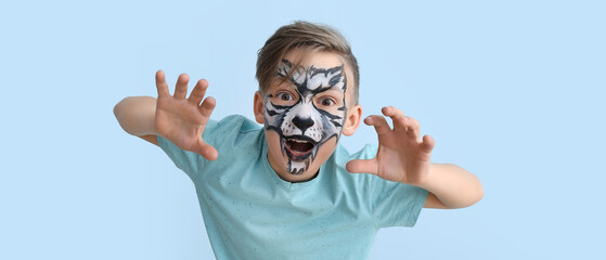 Canvas Print - Funny little boy with face painting on light blue background