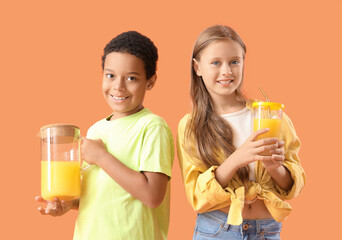 Wall Mural - Little children with cup and jug of fresh citrus juice on orange background