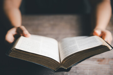 Canvas Print - Worship christian with bible concept. Young woman person hand holding holy bible with study at home. Adult female christian reading book in church. Girl learning religion spirituality and pray to god.