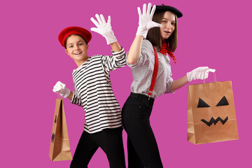 Sticker - Little girl with her mother dressed for Halloween as mimes with gift bags on purple background