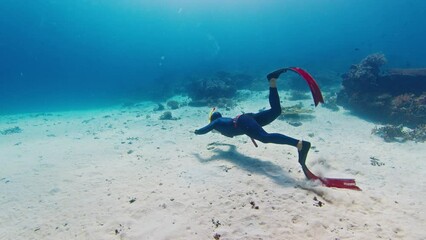 Sticker - Male freediver hangs in the tropical sea over the sandy bottom