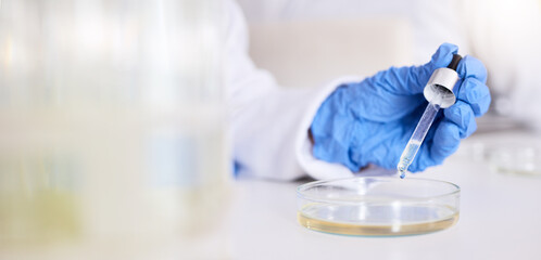 hand, petri dish and liquid, chemical and pipette in laboratory with scientist person and experiment