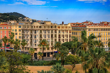 Canvas Print - Aerial view of Old Town or Vielle Ville buildings, the trees of Promenade du Paillon and Castle Hill or Colline du Chateau at sunset in Nice, France