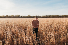 Boy Checking Soybeans In Golden Farm Field