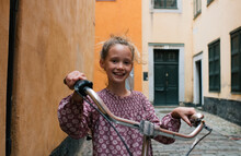 Child Holding A Bike In The Gamla Stan, Stockholm