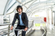 © Art_Photo - Portrait of hipster handsome businessman in suit with backpack looking forward while commuting riding bicycle on the street city way go to work.business travel transport bike concept