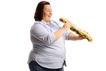 Wall Mural - Happy corpulent woman in eating a big baguette sandwich