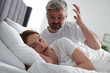 Irritated man near his snoring wife in bed at home