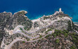 Vertical drone view of a mountain road next to the seashore in Oludeniz Fethiye Turkey