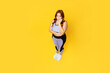 Full body top view from above sad young chubby plus size big fat fit woman wears blue top warm up training stand on scales isolated on plain yellow background studio home gym. Workout sport concept.