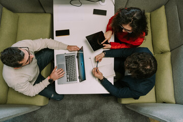 A high view photo of three colleagues working together at modern co working space