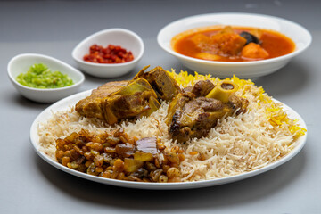 Selective focused delecious Lamb mandy / mandi rice with garlic sauce and chilli sauce served in plate.Arabian main course complete with side dishes and dessert. Mutton Mandhi, Mutton Mandi.