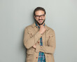 © Viorel Sima - happy man with glasses touching beard and smiling with folded arms