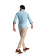 © Viorel Sima - rear view of casual man wearing blue denim shirt walking and looking to side