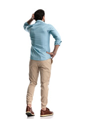 Wall Mural - back view of confused young man scratching head and thinking