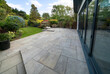 © Wormsmeat - Beautiful indian sandstone patio with attractive garden and bifold doors.