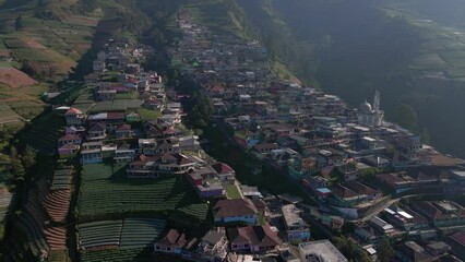 Wall Mural - View of countryside on the slope of mountain during sunny day. Drone shot of Nepal van Java on the slope of Sumbing Mountain, Indonesia - 4K aerial view