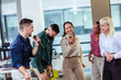 © Mediteraneo - Group of professional people singing karaoke in the modern office