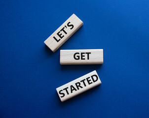 Wall Mural - lets get started symbol. concept words lets get started on wooden blocks. beautiful deep blue backgr