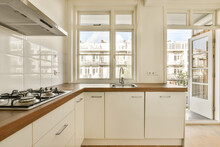 Kitchen With White Cabinets And Sink By Window