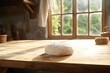 White wheat pizza dough resting on a wooden table, rustic kitchen ambiance