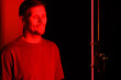 © Girts - Embarking on red light therapy, the gentleman faces the camera in a portrait at a beauty salon, utilizing a red light device as a component of his anti-aging cosmetic treatment