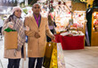 © JackF - Happy married couple with packages of gifts at new year street fair