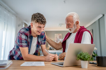 student caucasian male teenager and his grandfather or professor study