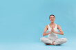 © New Africa - Beautiful young woman practicing yoga on light blue background, space for text. Lotus pose