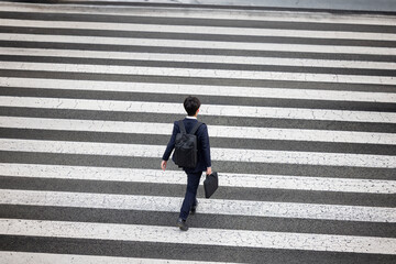 俯瞰で見る横断歩道を渡るビジネスマン