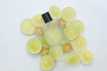 Sticker - Kumquat and lime cut in round slices arranged under a transparent bottle. Mockup design. Lime and Kumquat are often used to accent flavors in foods