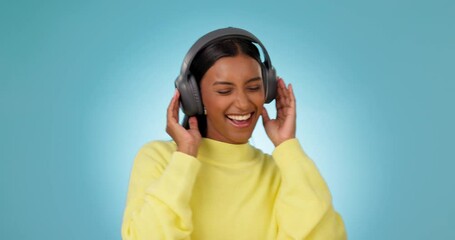 Poster - Dance, happy woman and music headphones in studio for celebration of freedom, party or hearing audio song on blue background. Excited indian model listening to multimedia, sound or radio subscription