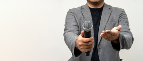 Canvas Print - Close up businessman speaker hand holding High quality dynamic microphone and singing song or speaking talking with people on isolated white background. Male testing microphone voice for interview