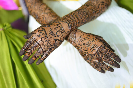 An Indian bride showing her hand's mehndi tattoos design