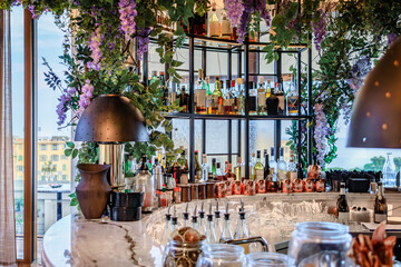 Wall Mural - An empty rooftop bar decorated with wisteria waiting for customers, counter and bottles on display, Nice, French Riviera, South of France