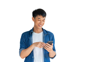 A handsome Asian man wearing a blue jeans shirt is happily playing on a mobile phone isolated on a white background. Typing and chatting with friends via smartphone. Online social concept.